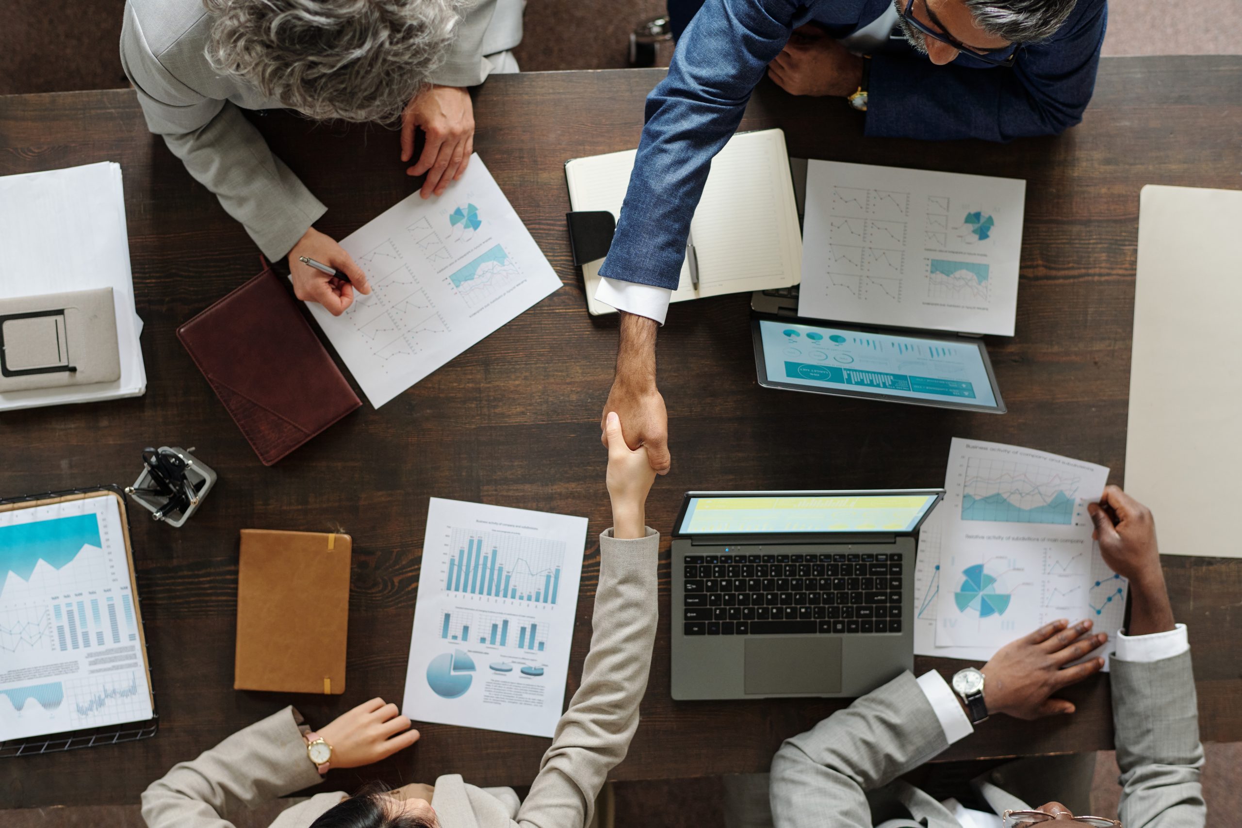 Business professionals shaking hands around a table